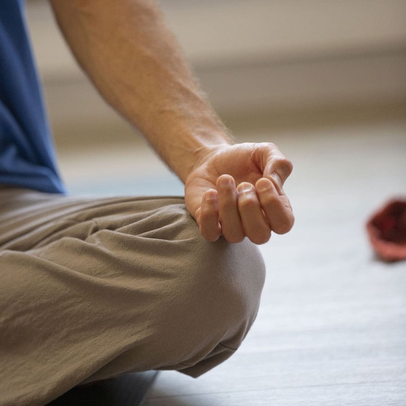 Hender i meditasjonsstilling hvilende på kneet